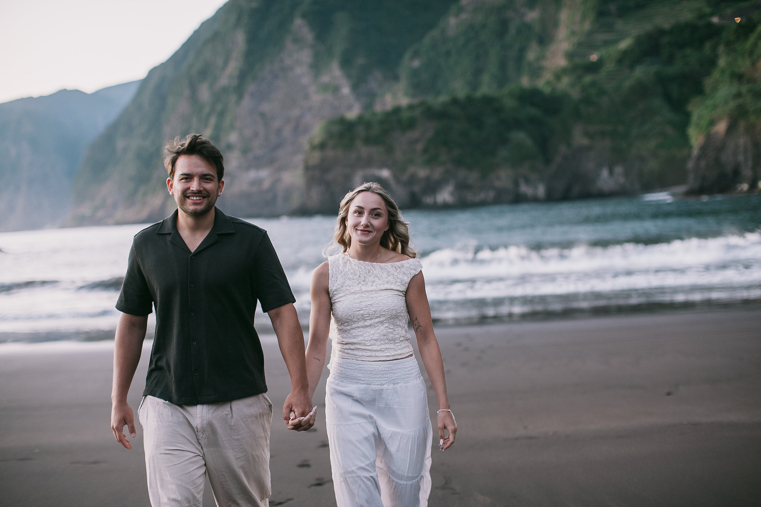 Smiling at each other mid-walk on the volcanic sand, Seixal Beach, Madeira