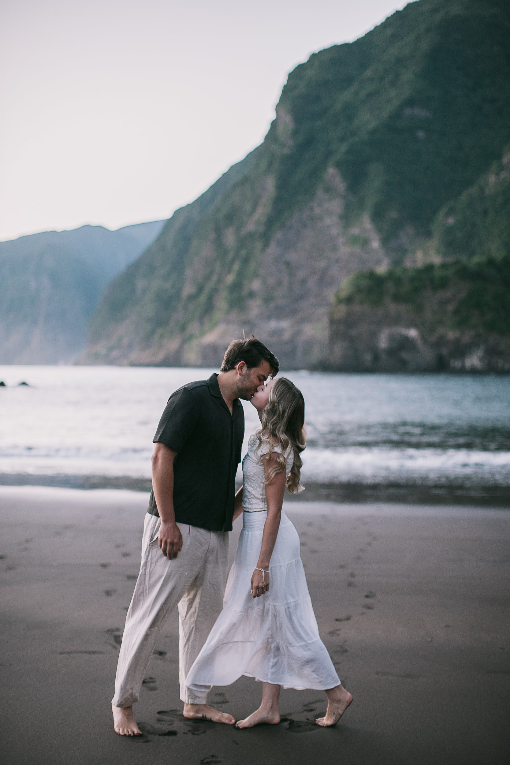 Kissing at the tide line, mountains soft behind, Seixal Beach, Madeira