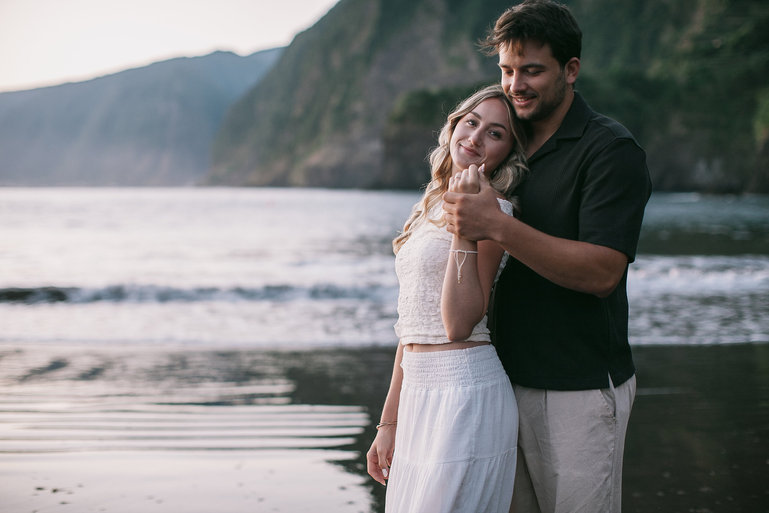 She leans back into his arms at the water, Seixal Beach, Madeira