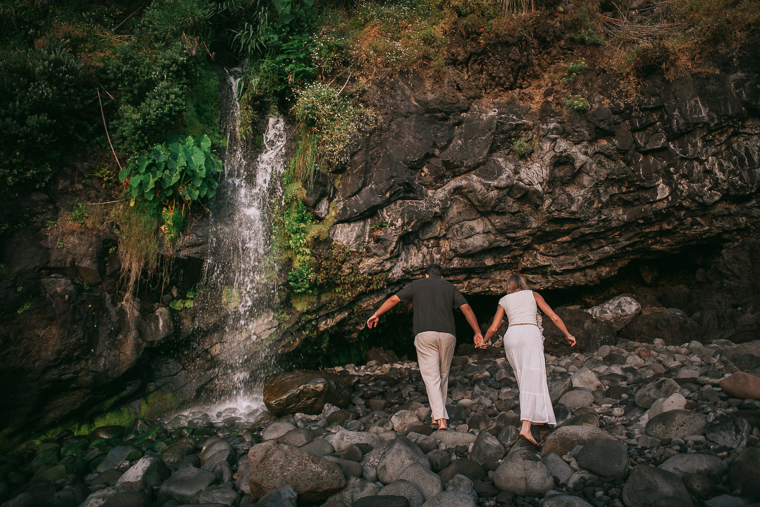 Hand in hand on the boulders by the small waterfall, Seixal, Madeira