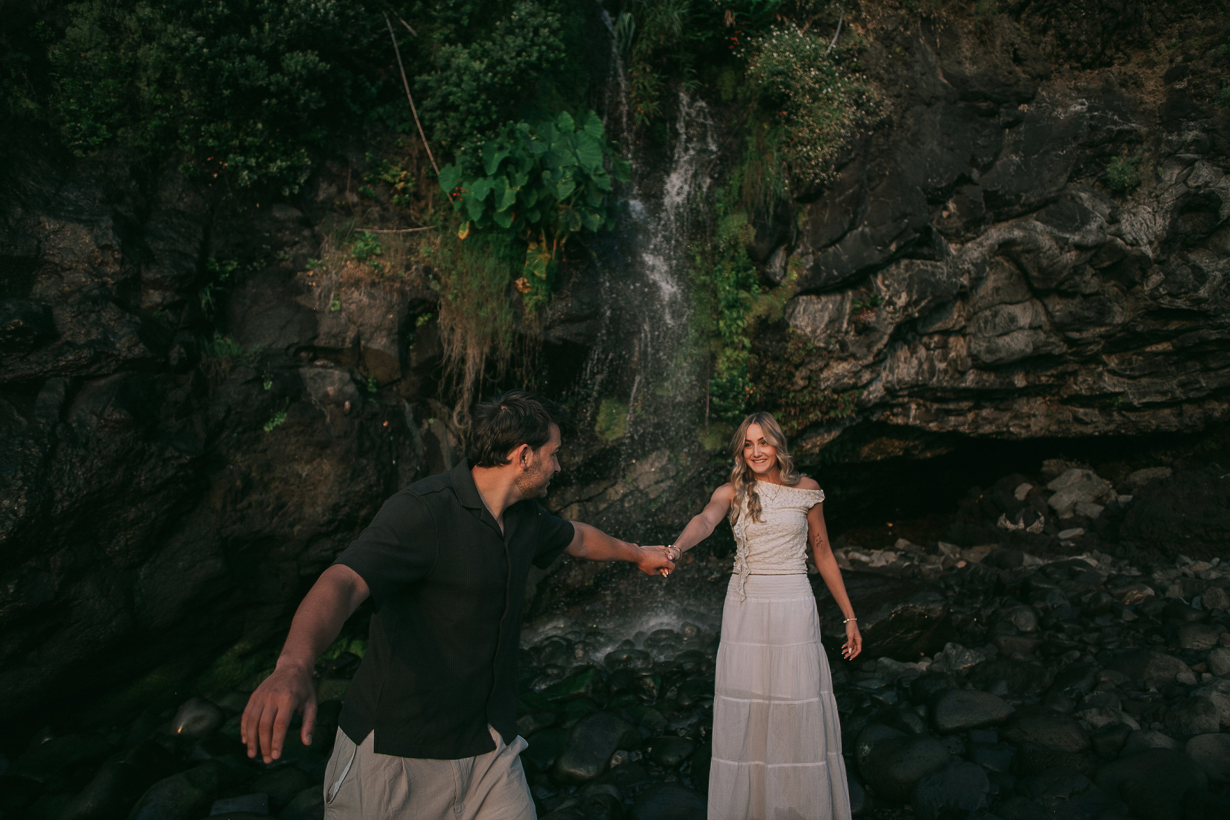 Playing on the boulders beneath the waterfall, Seixal Beach, Madeira