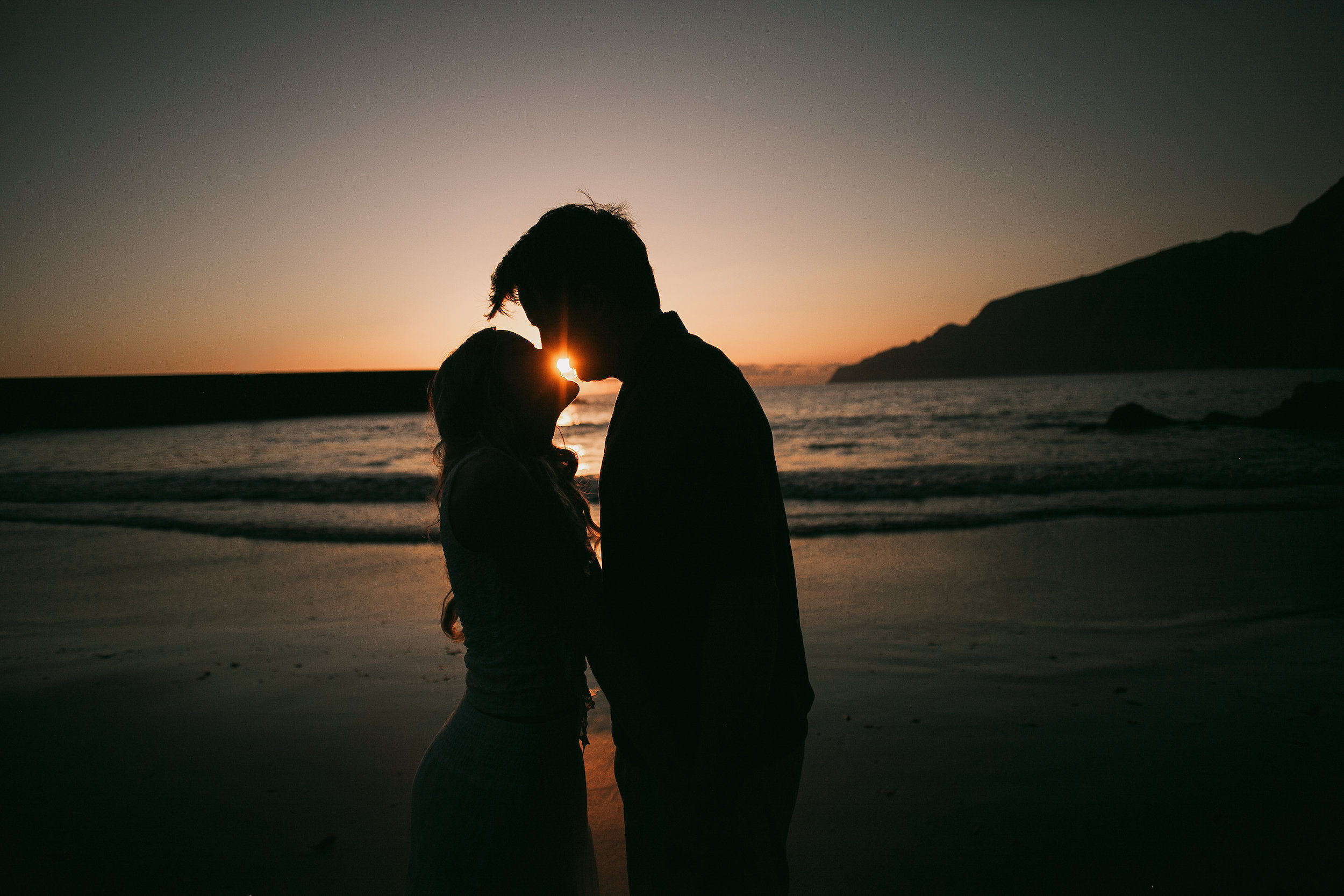 Silhouetted forehead to forehead as the sun flares between them, Seixal, Madeira