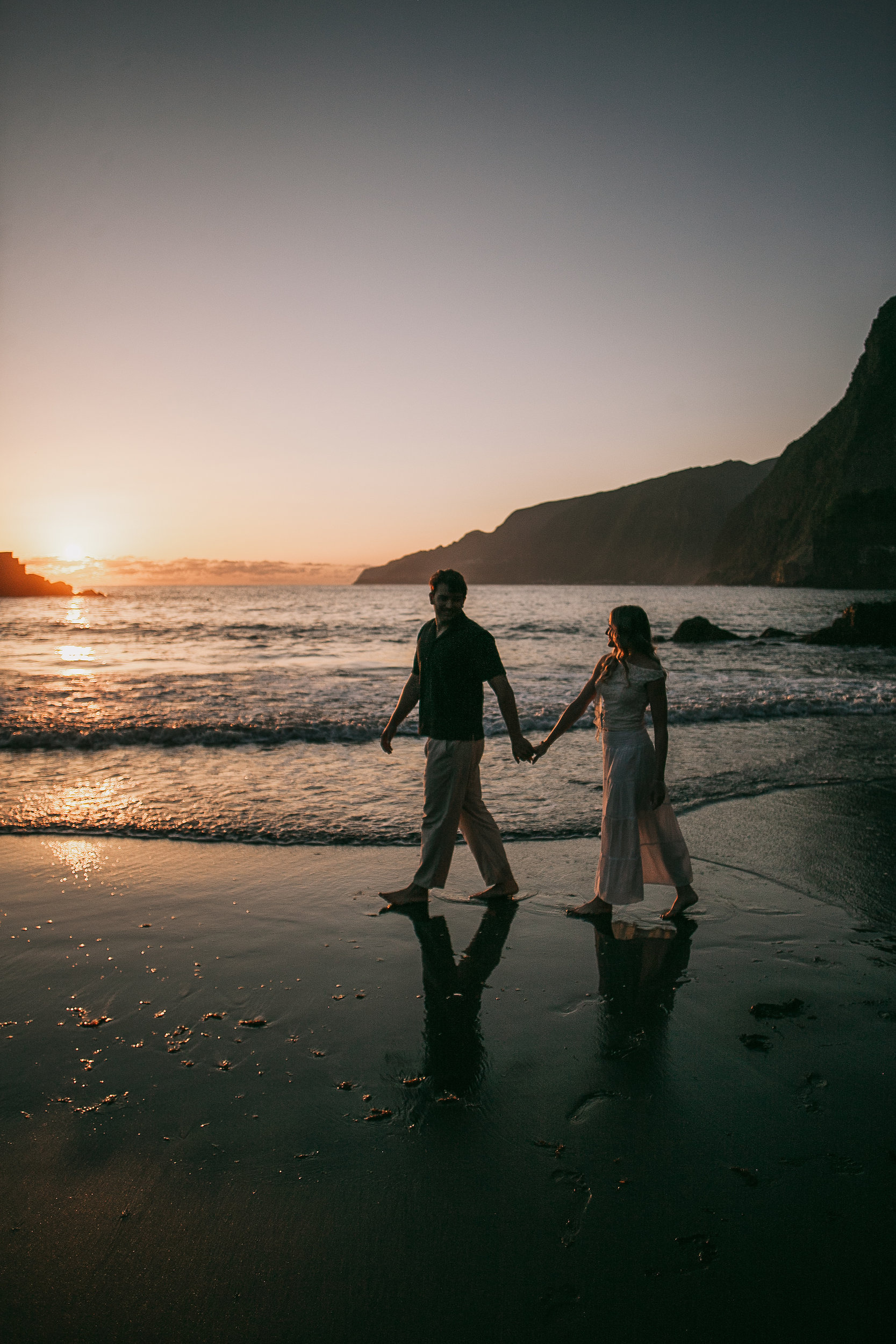Hand in hand at the surf as the sun sets over the bay, Seixal, Madeira
