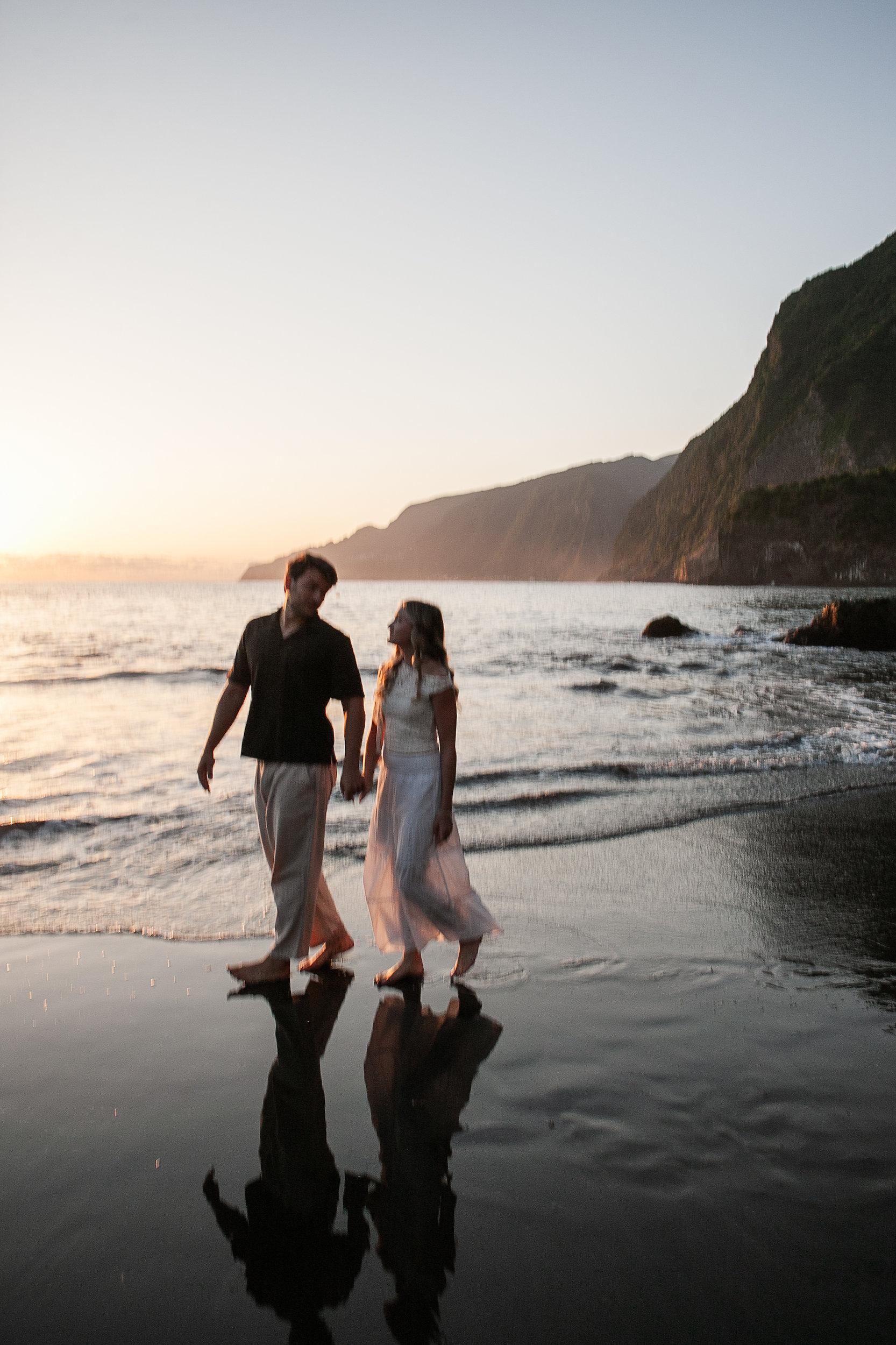 The sun dropping behind them at the waterline, Seixal Beach, Madeira