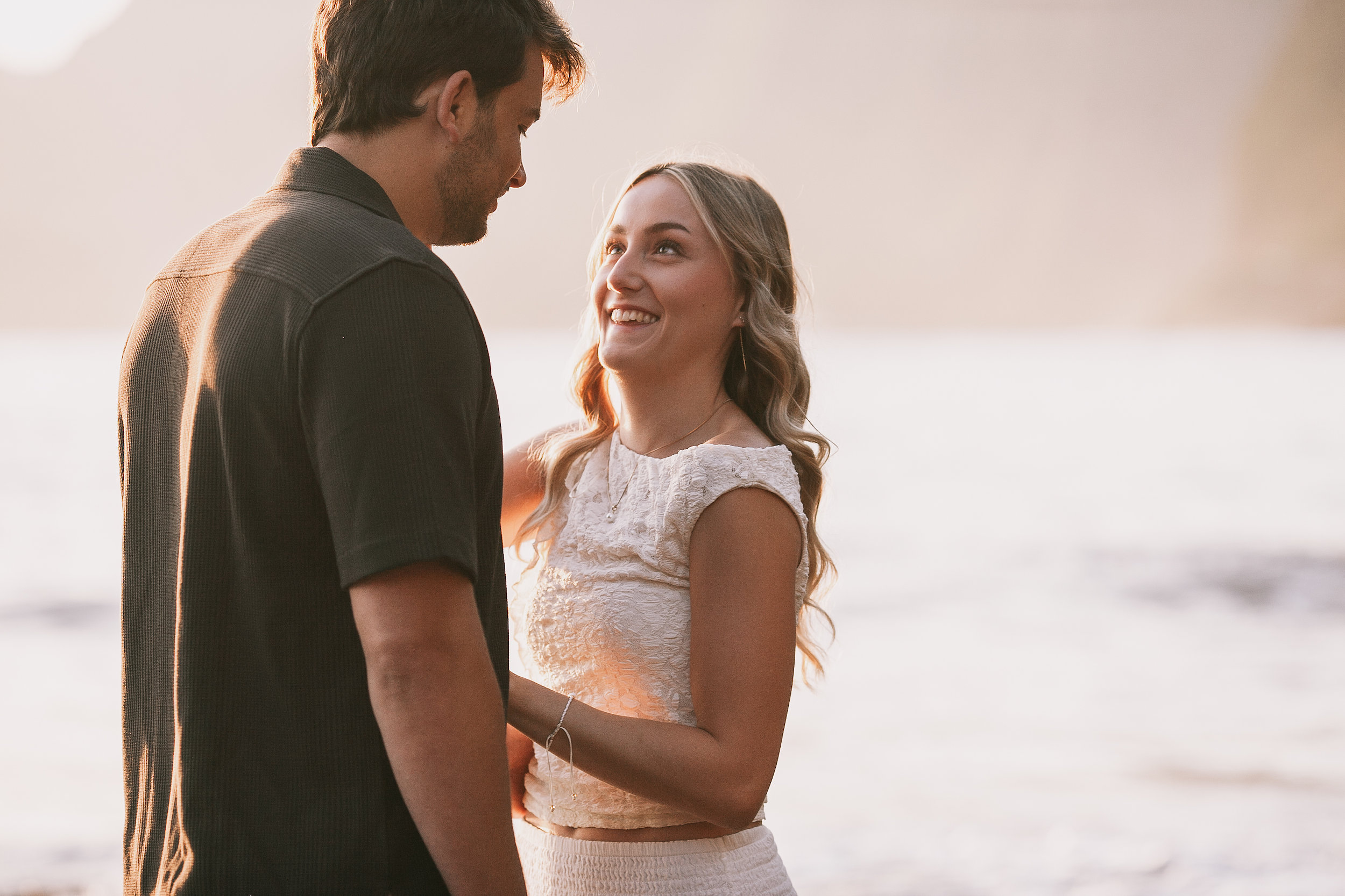 She smiles up at him against the hazy cliffs, Seixal Beach, Madeira