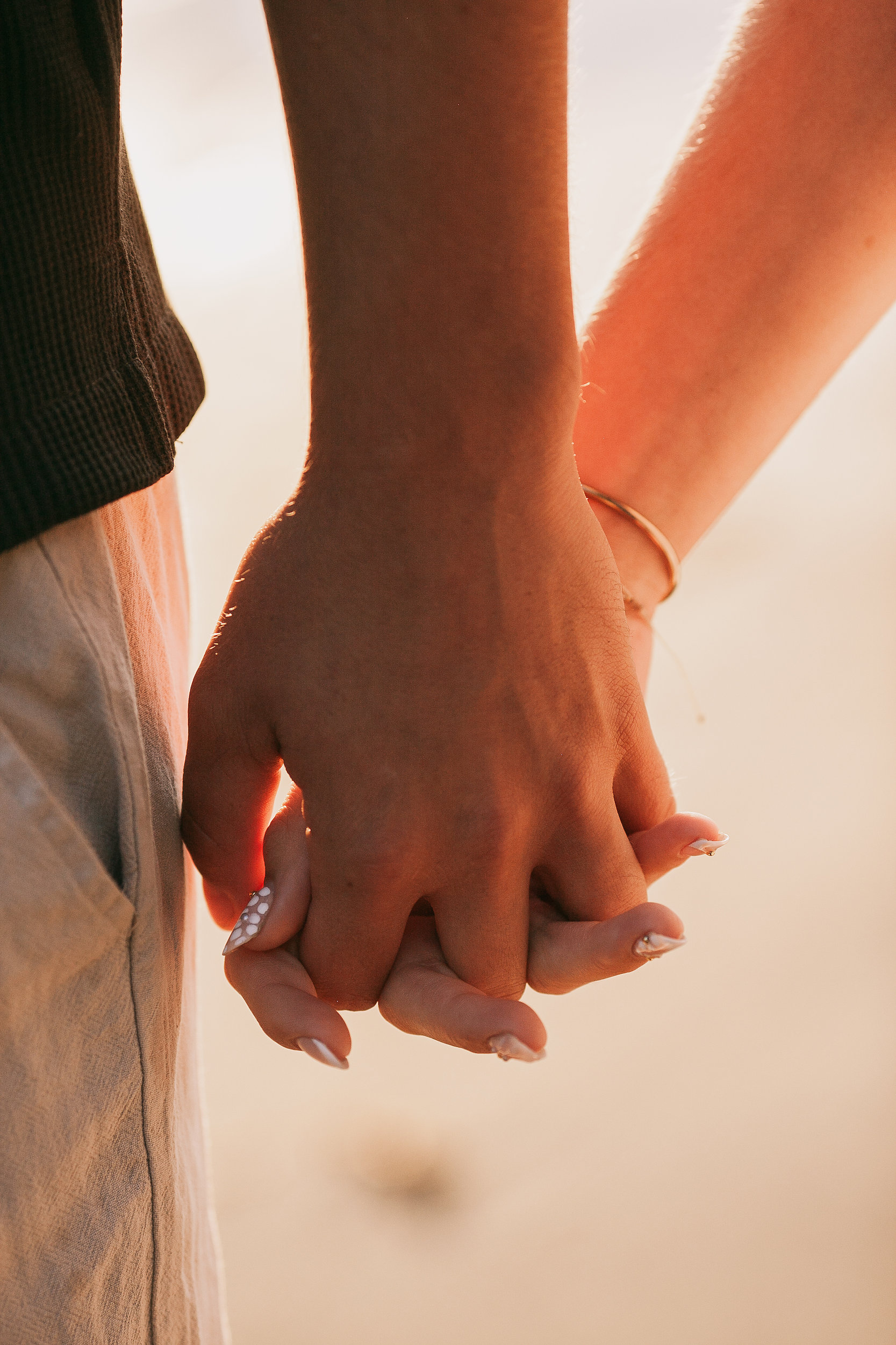 Their hands linked in the low sun, detail at Seixal, Madeira