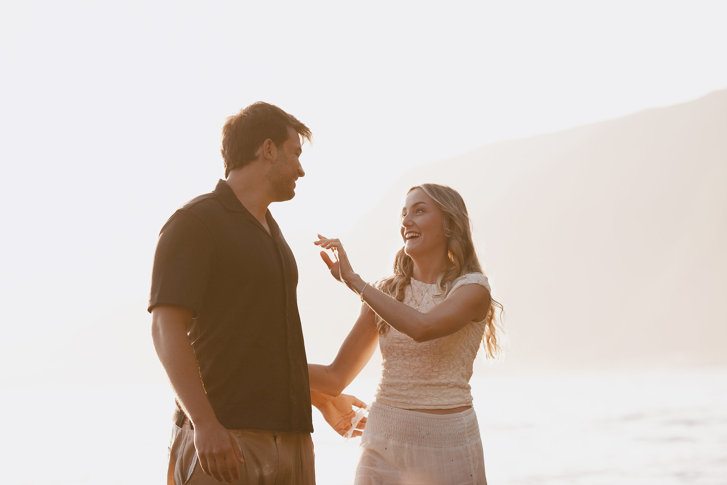 She reaches for his face laughing in the pale light, Seixal Beach, Madeira