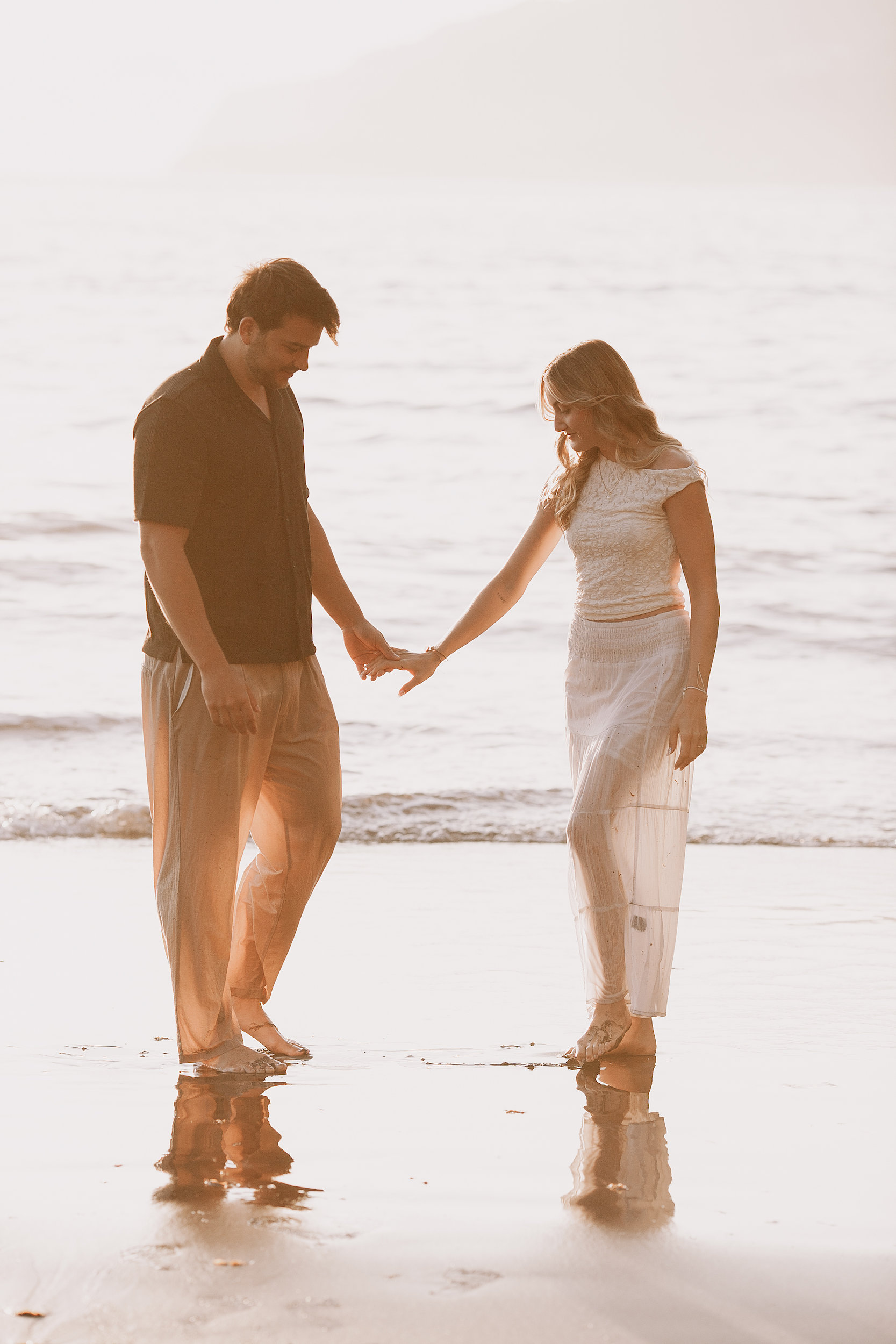 Holding hands dripping wet on the shore, Seixal, Madeira