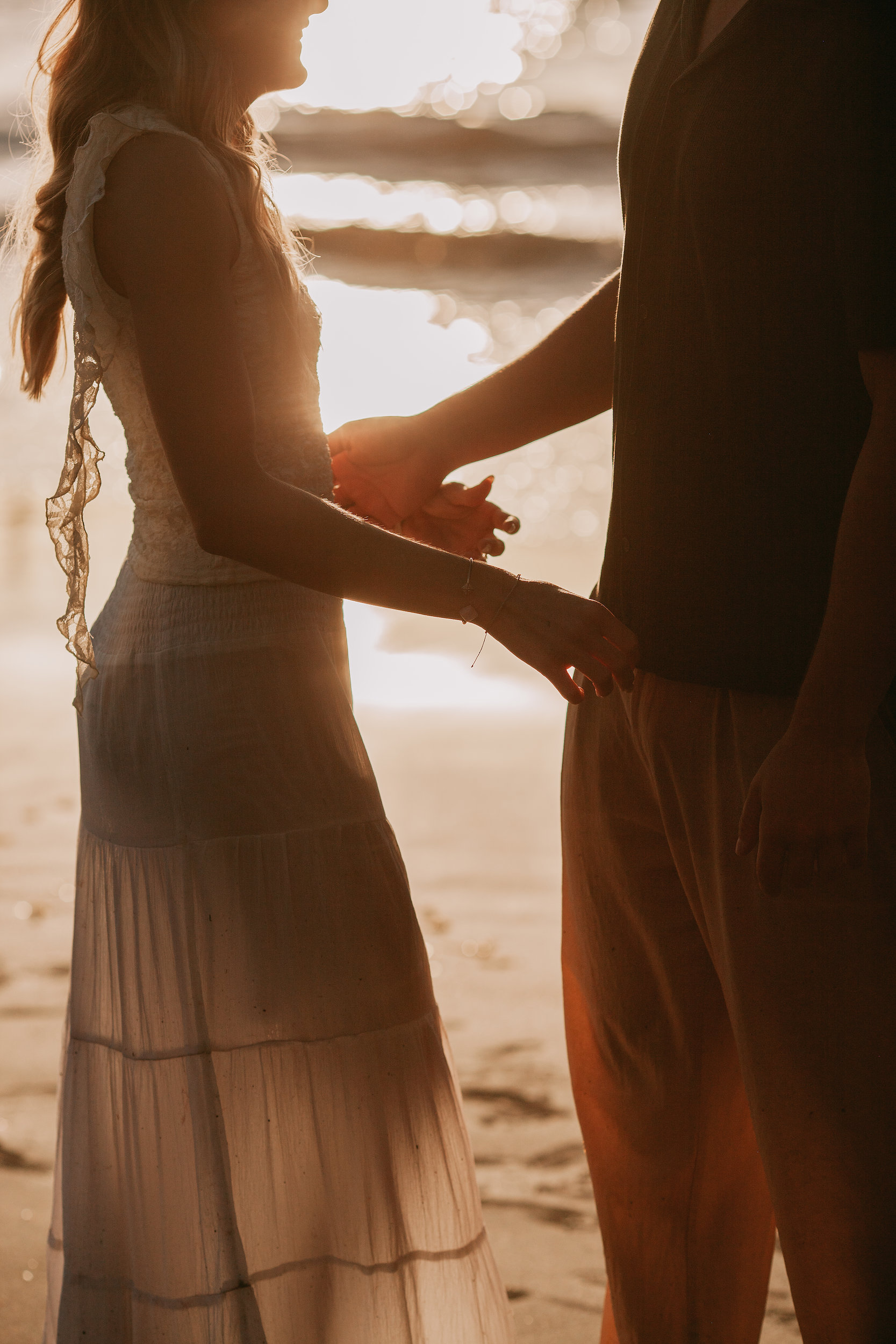Their hands joined against the setting sun, silhouette at Seixal, Madeira