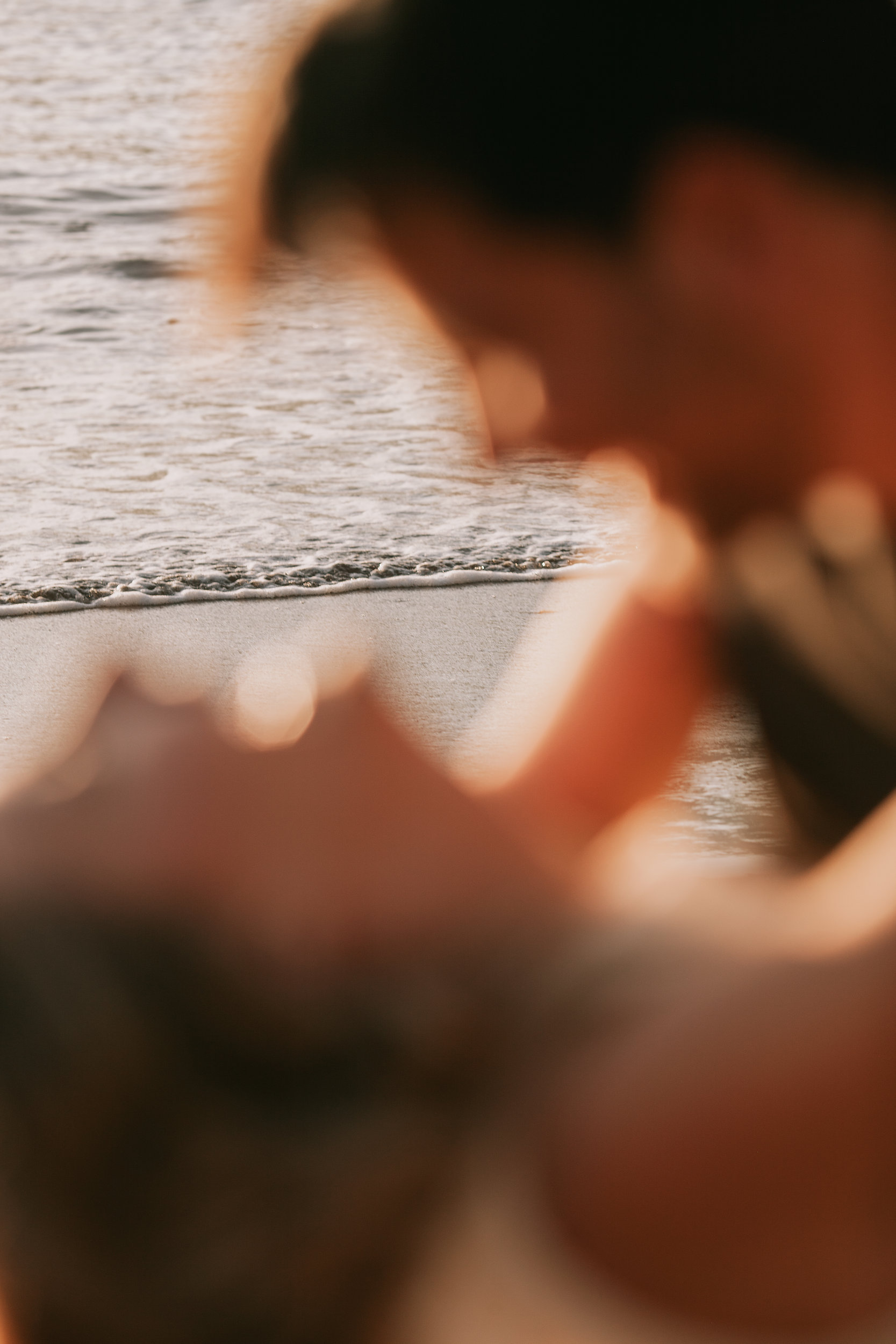 Their held hands blurred in the foreground as they kiss, Seixal, Madeira