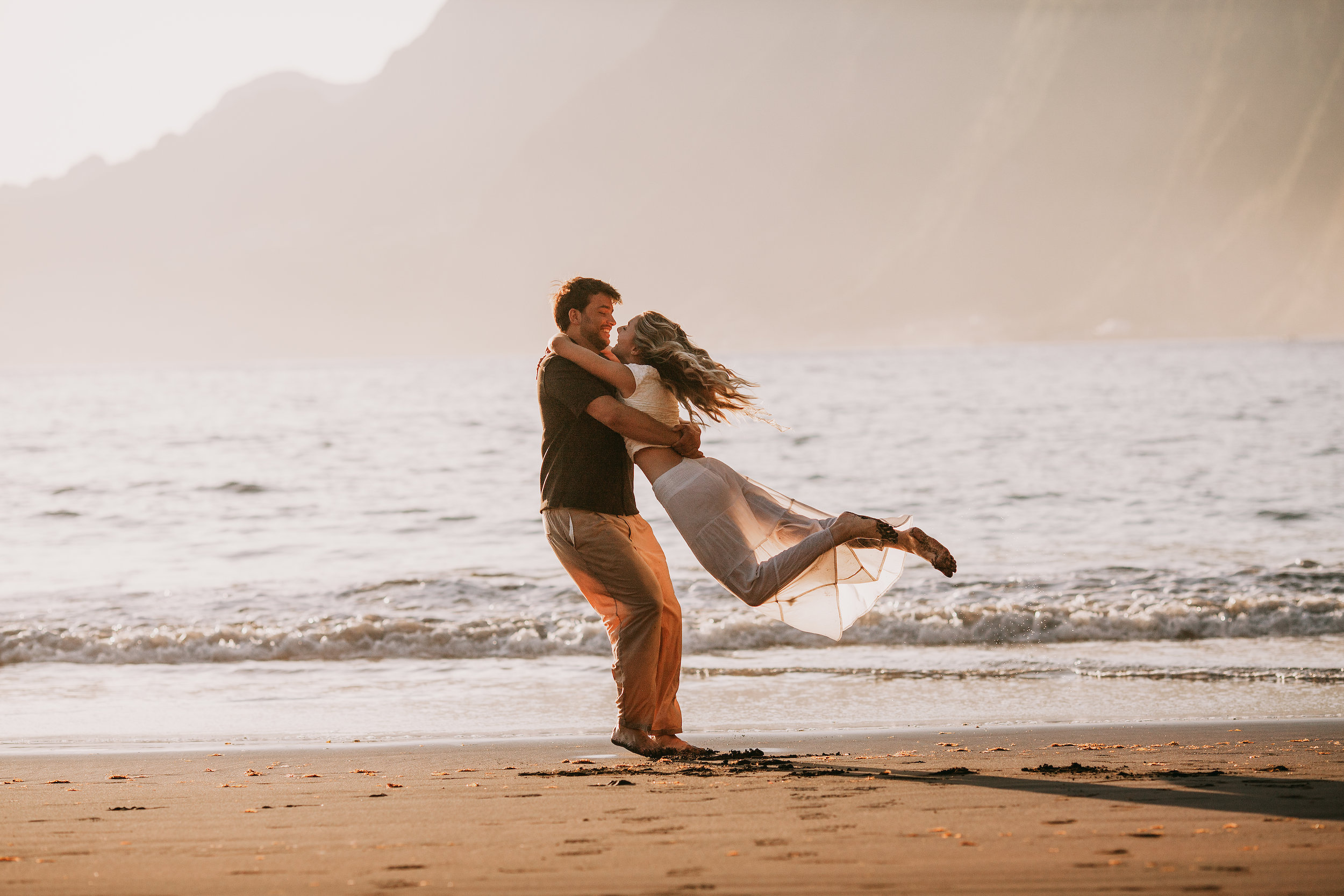 He swings her off her feet in the surf, Seixal, Madeira
