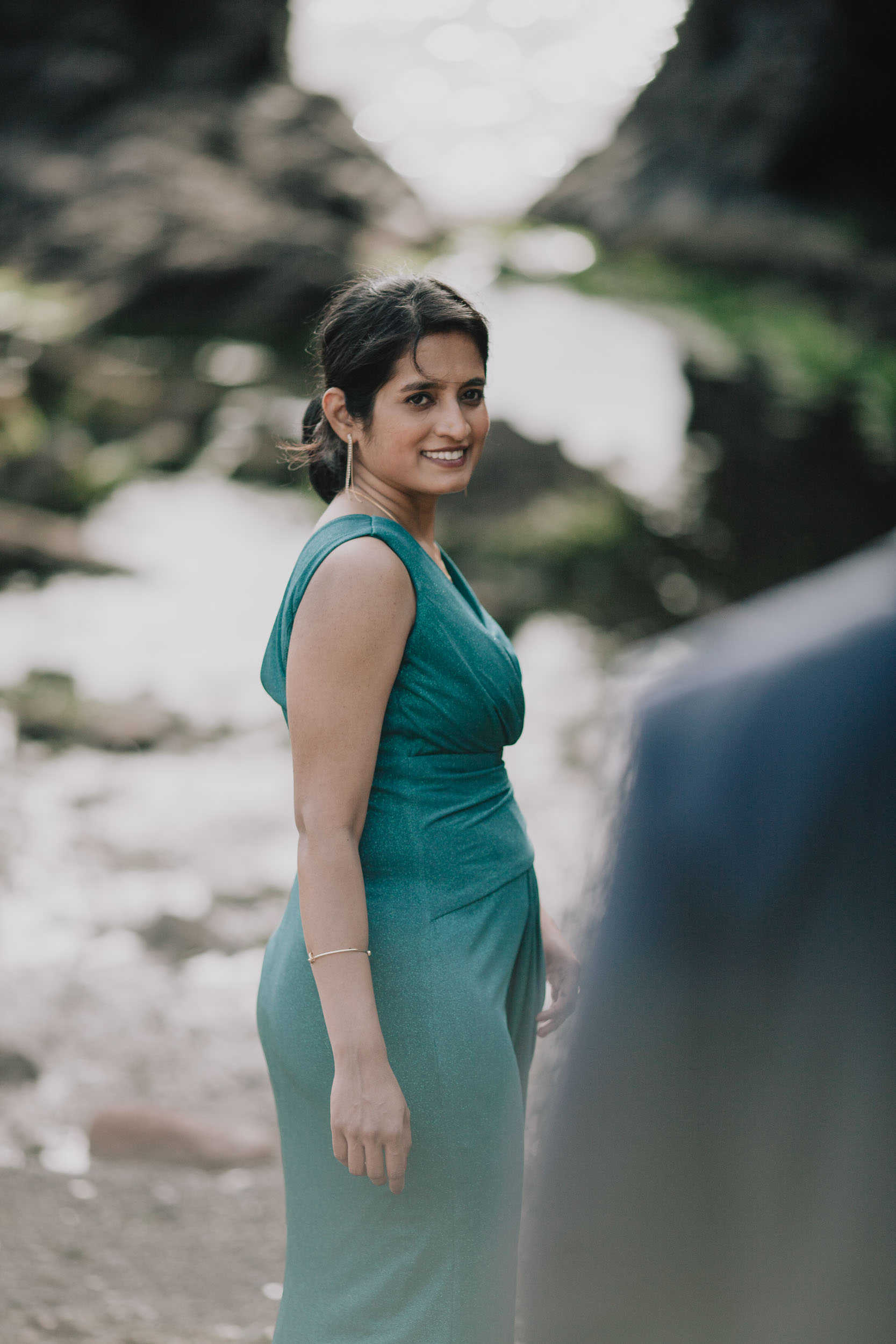 Portrait of the bride glancing back over her shoulder, the groom soft in the foreground, Câmara de Lobos, Madeira