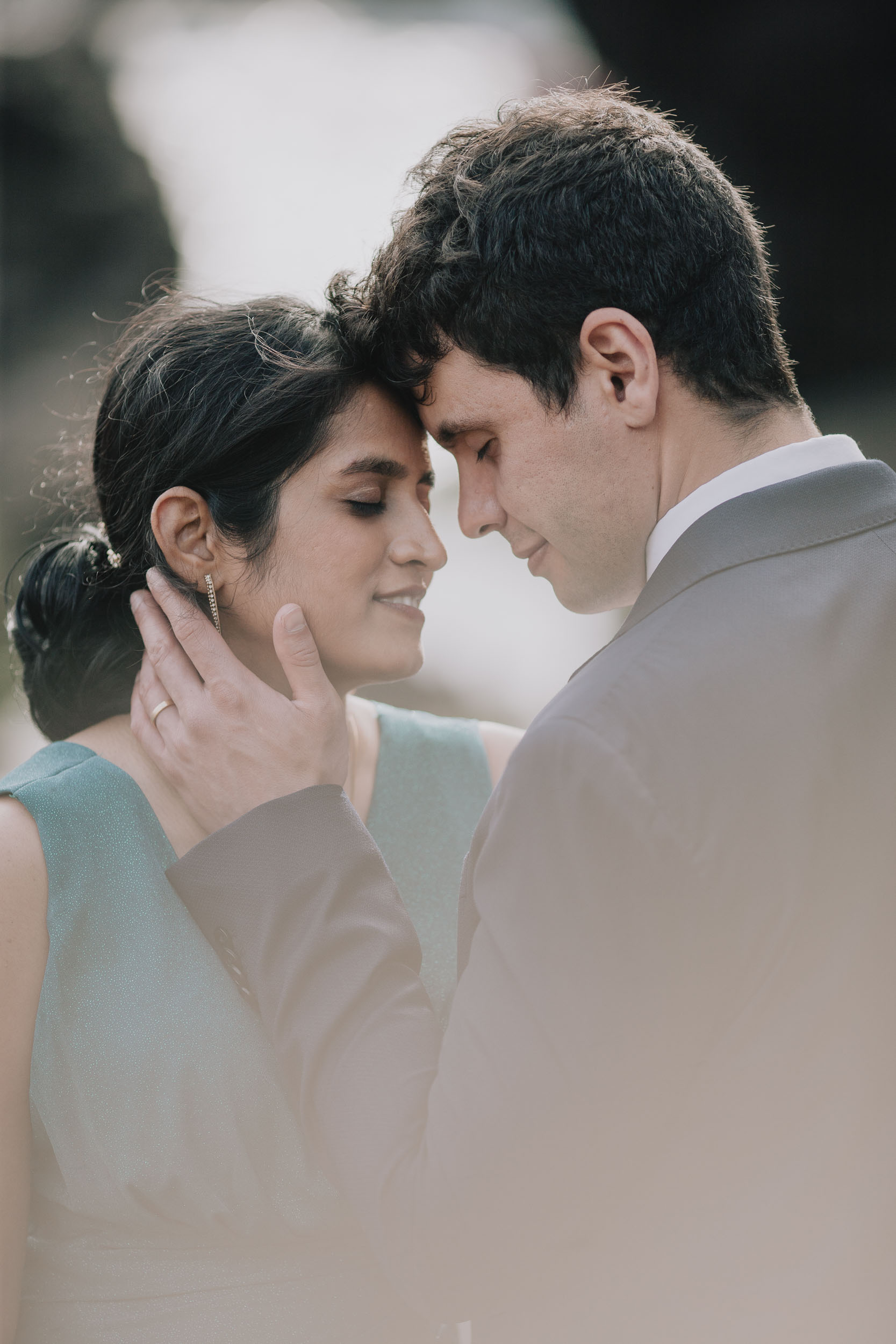 Close portrait of the couple with foreheads touching and eyes closed, the groom's hand at the bride's cheek, Câmara de Lobos, Madeira
