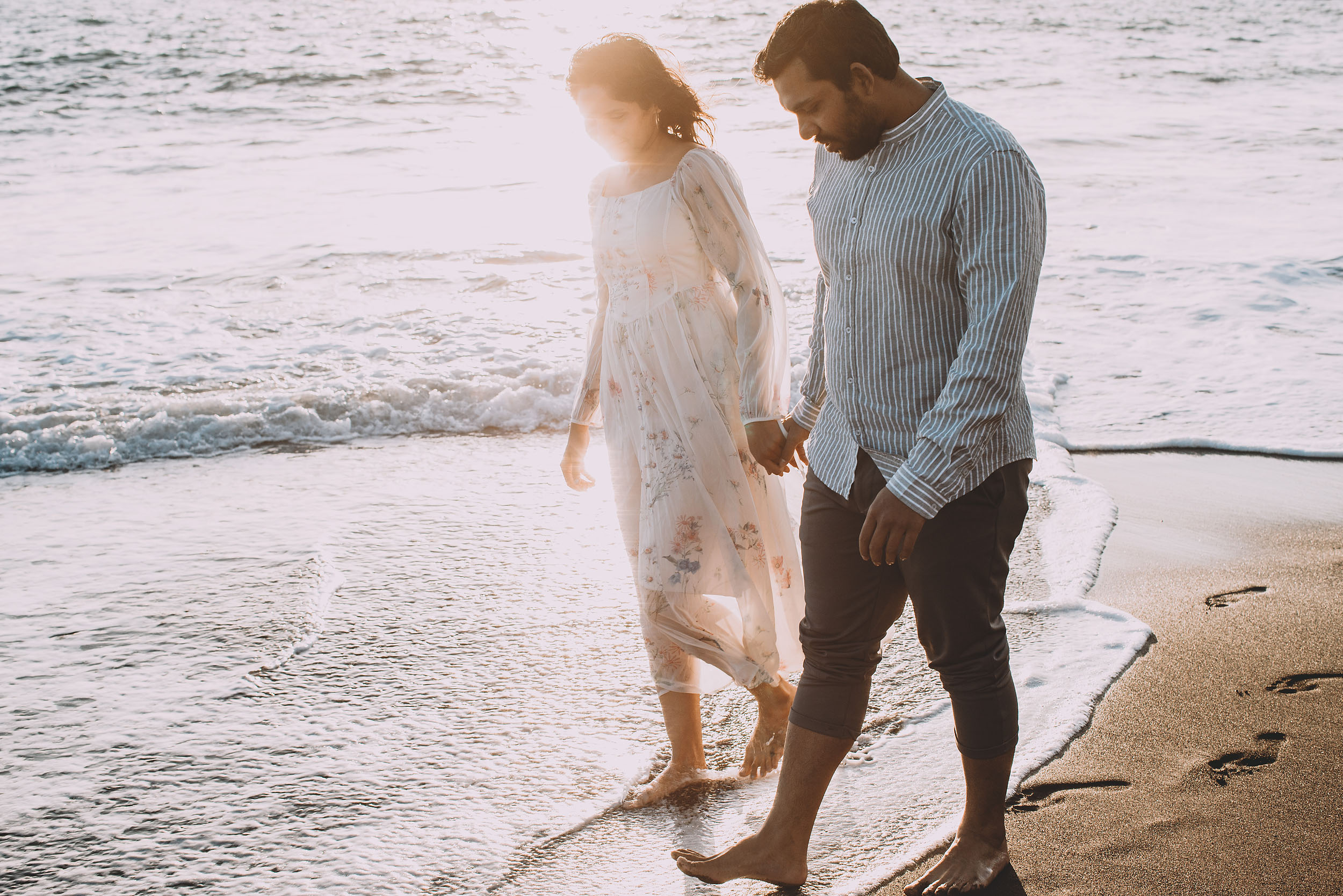 Couple walking barefoot along the shoreline at Praia Formosa, Funchal, soft afternoon light, Madeira
