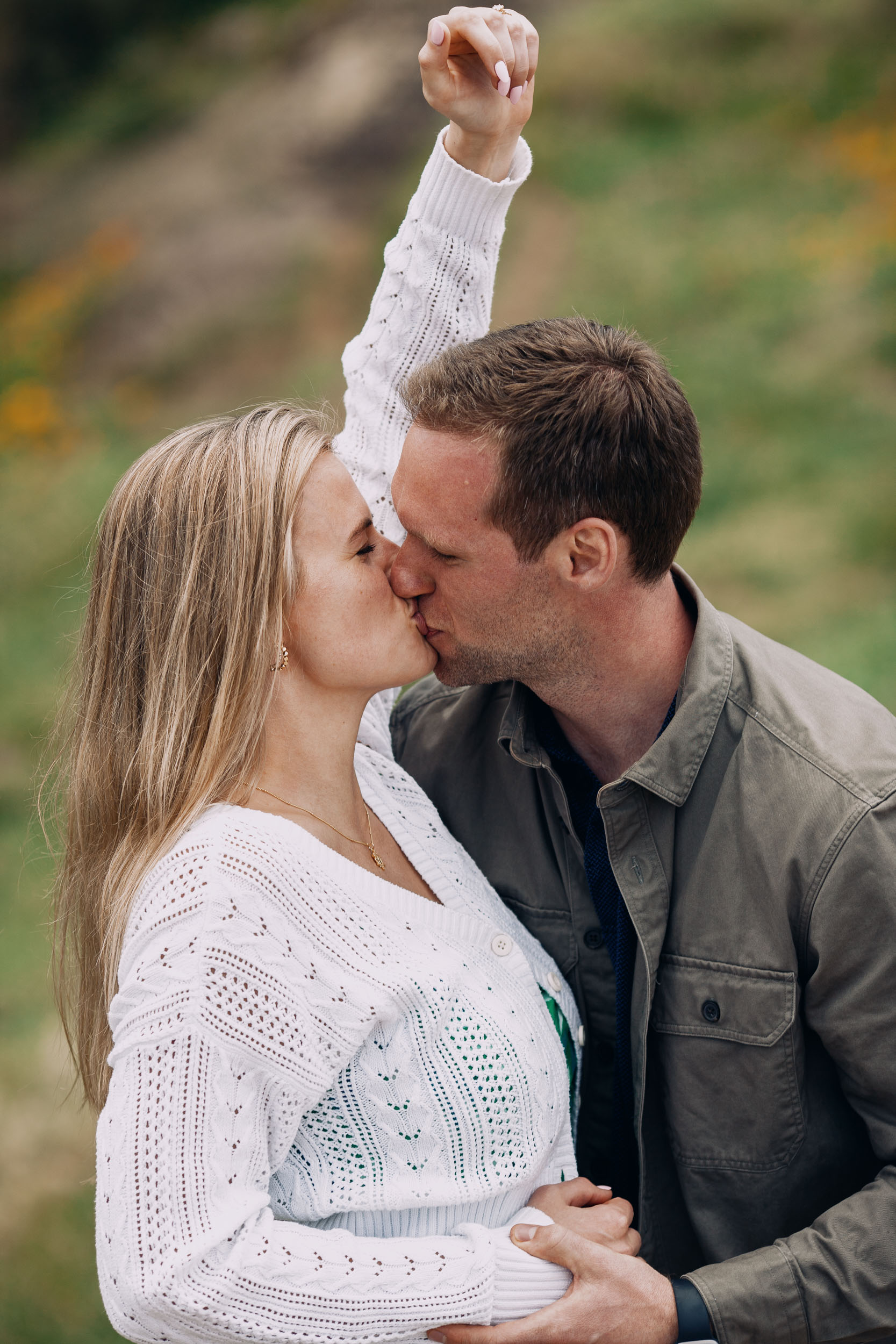 Newly engaged couple kissing with ring raised at Miradouro do Guindaste, Madeira