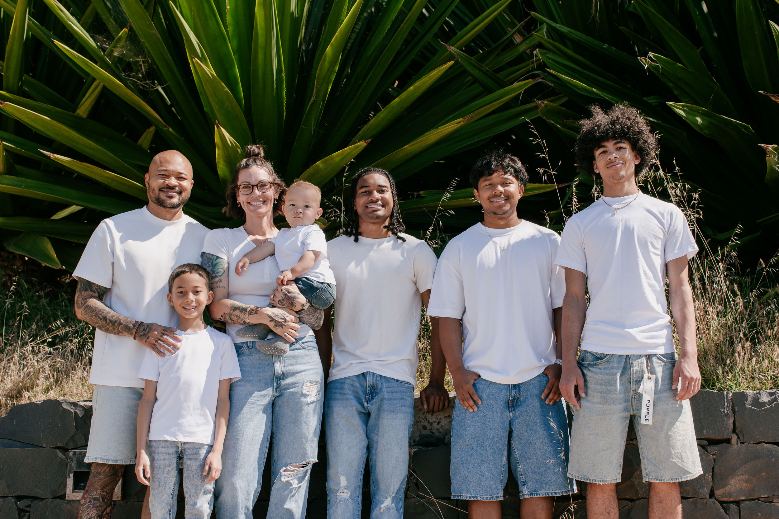 Family of seven in white and denim in front of a large agave plant, all smiling, Praia Formosa, Funchal, Madeira