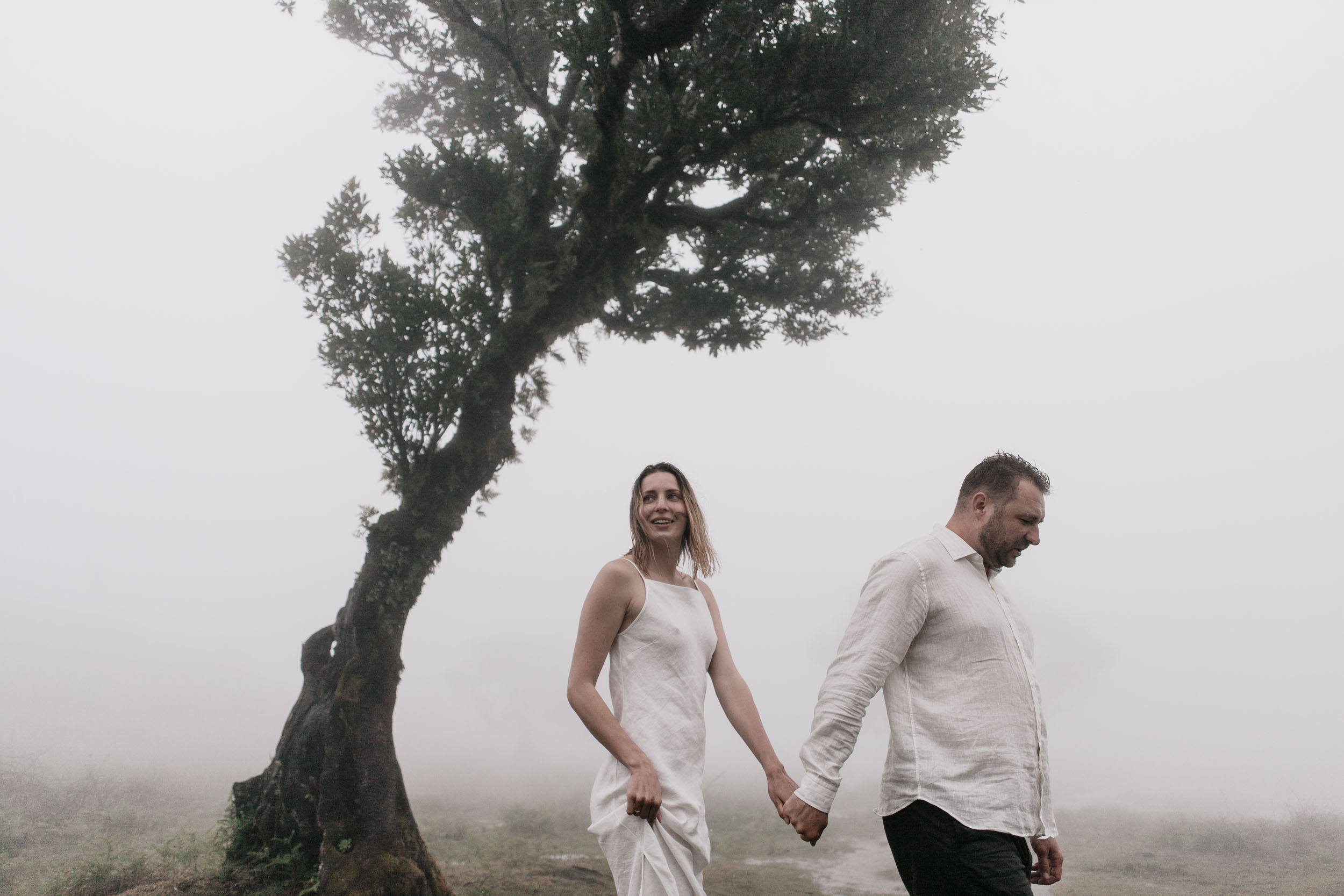 Couple walking together through the moss-covered laurel grove at Fanal, Madeira