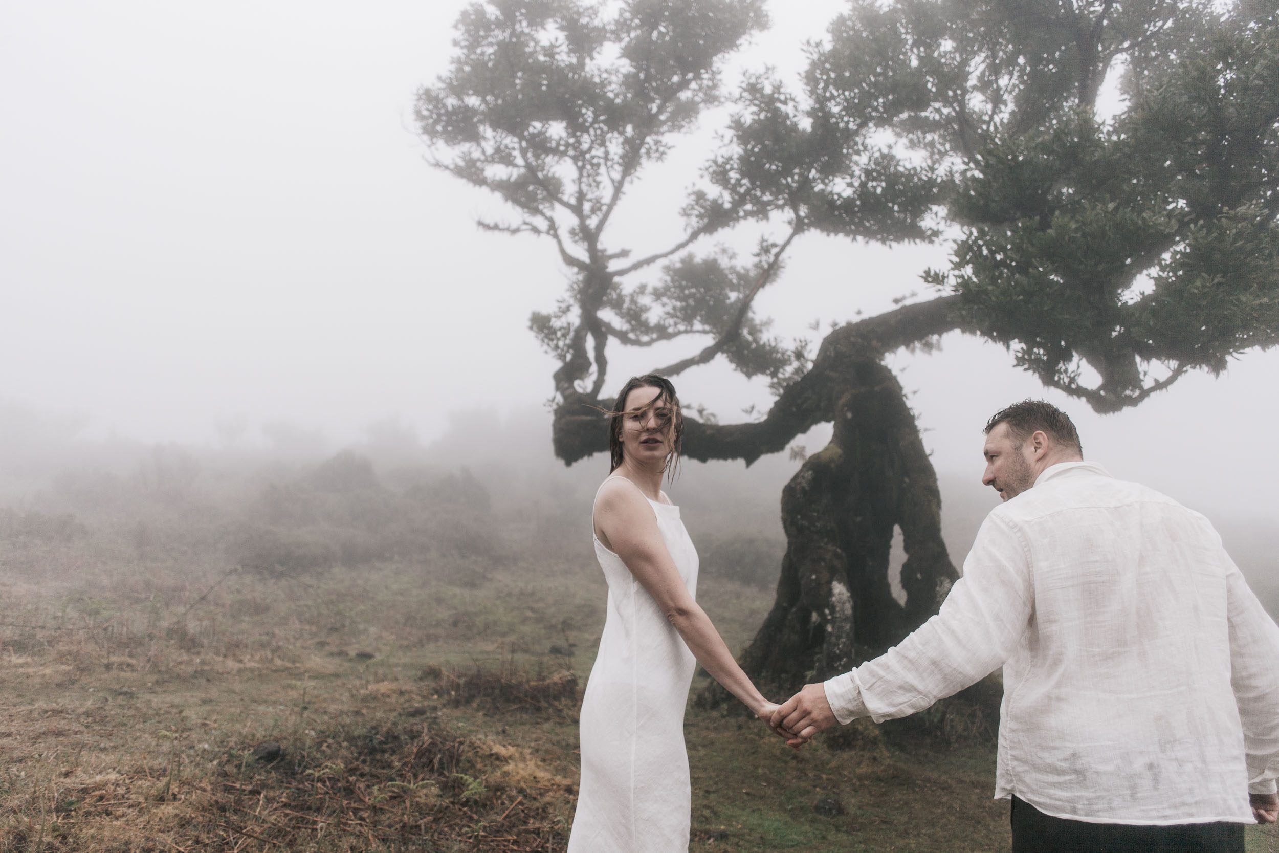 Couple walking together through the moss-covered laurel grove at Fanal, Madeira