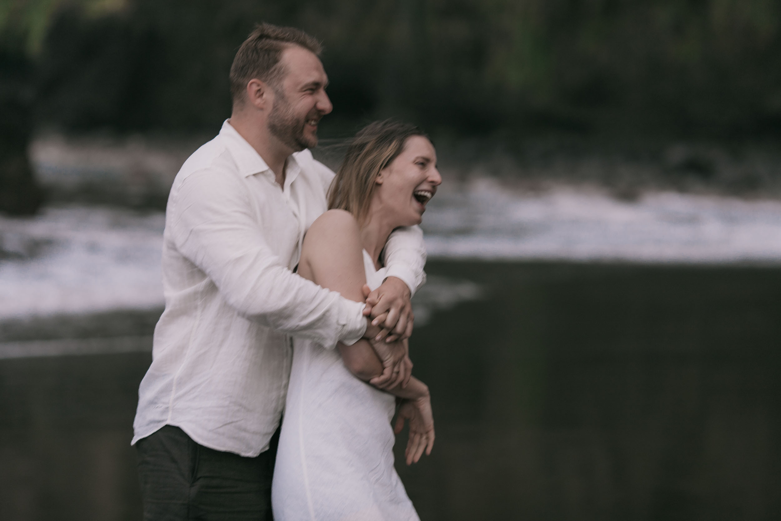 Tender moment at the edge of the surf, white linen, north Madeira coast