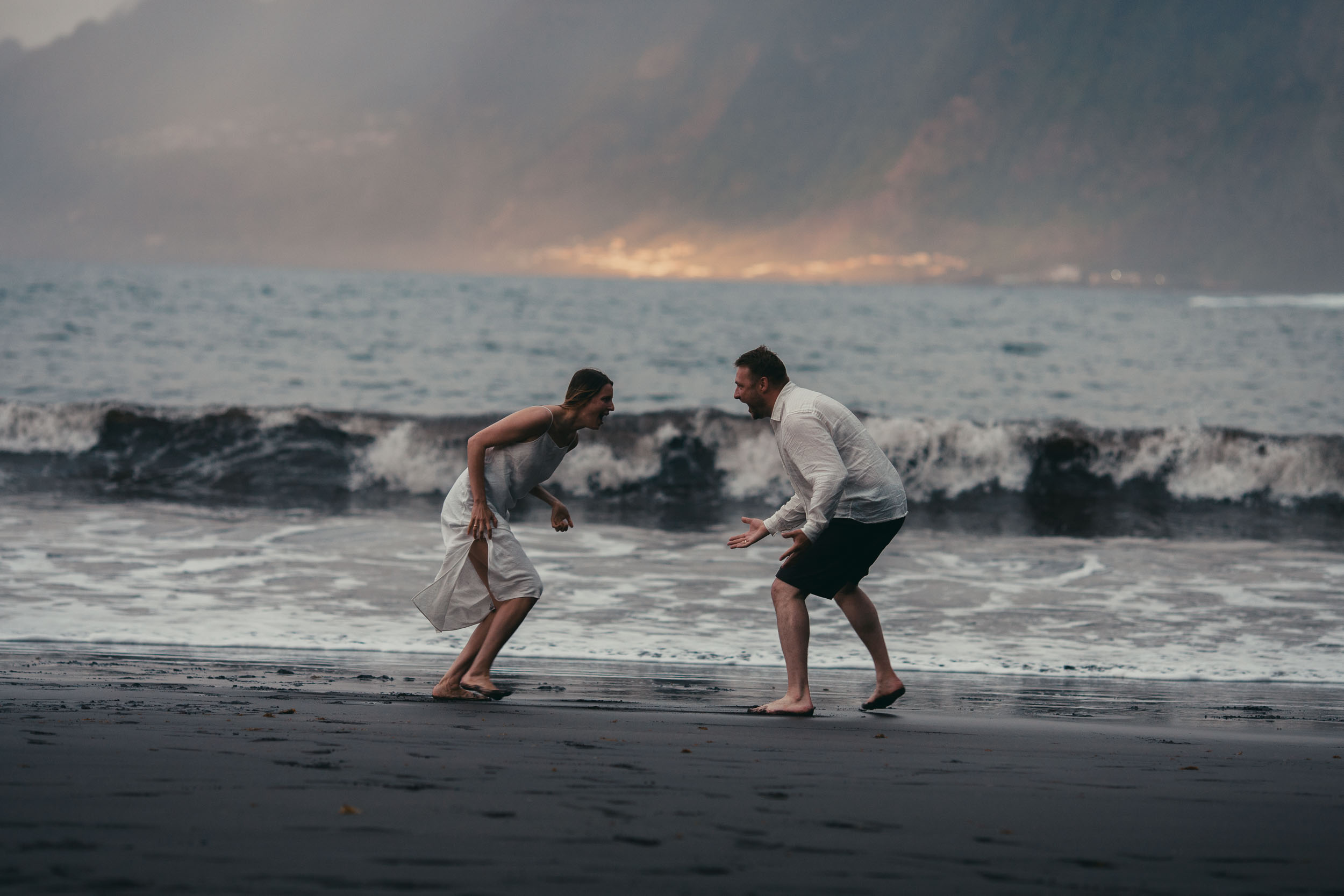 Golden light on the Atlantic, silhouettes of the couple in the surf, north Madeira coast