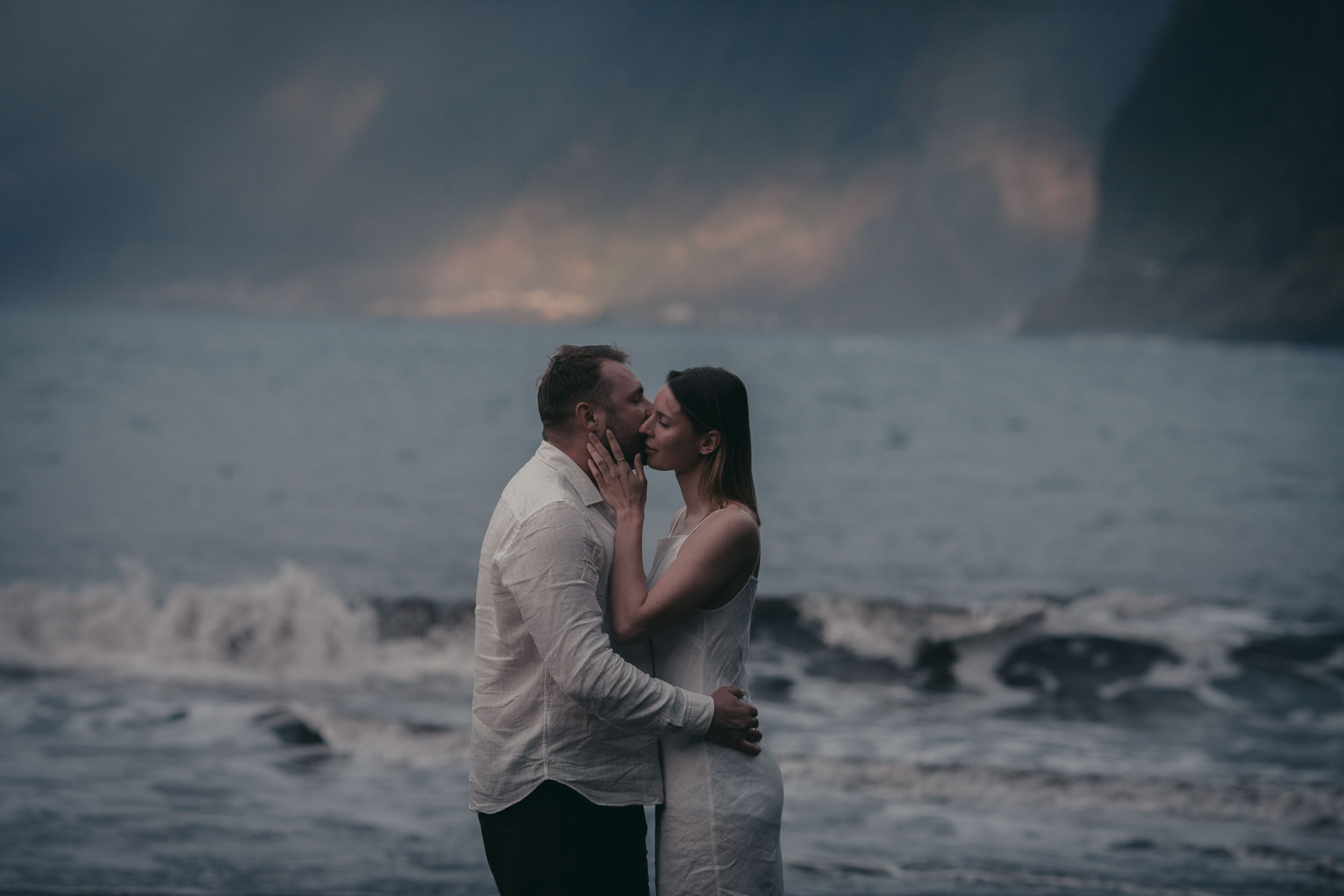 Close intimate moment at golden hour, the couple in soft warm light, Atlantic behind, Madeira