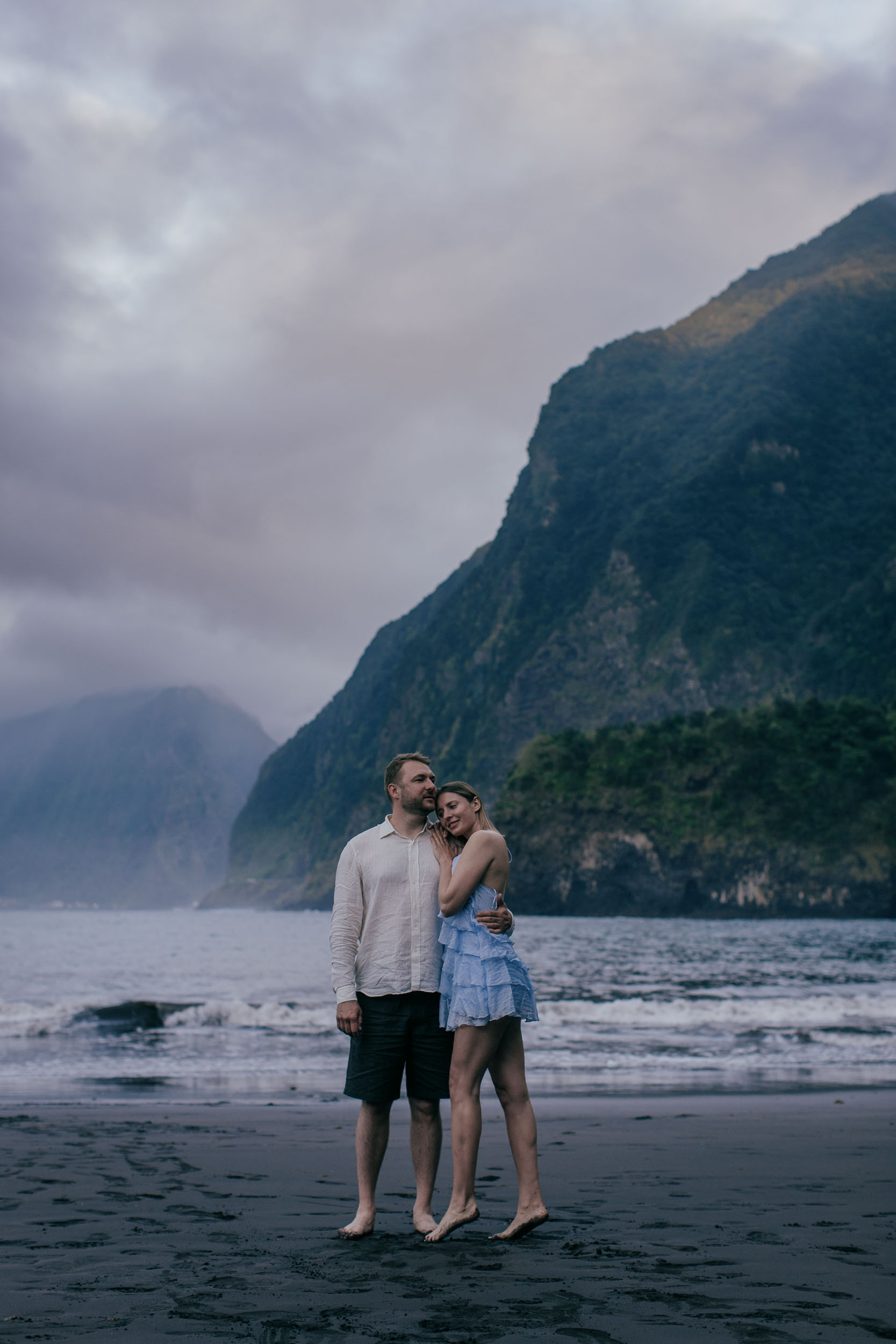 Couple in white at the edge of the surf during golden hour, soft focus and warm tones, Madeira