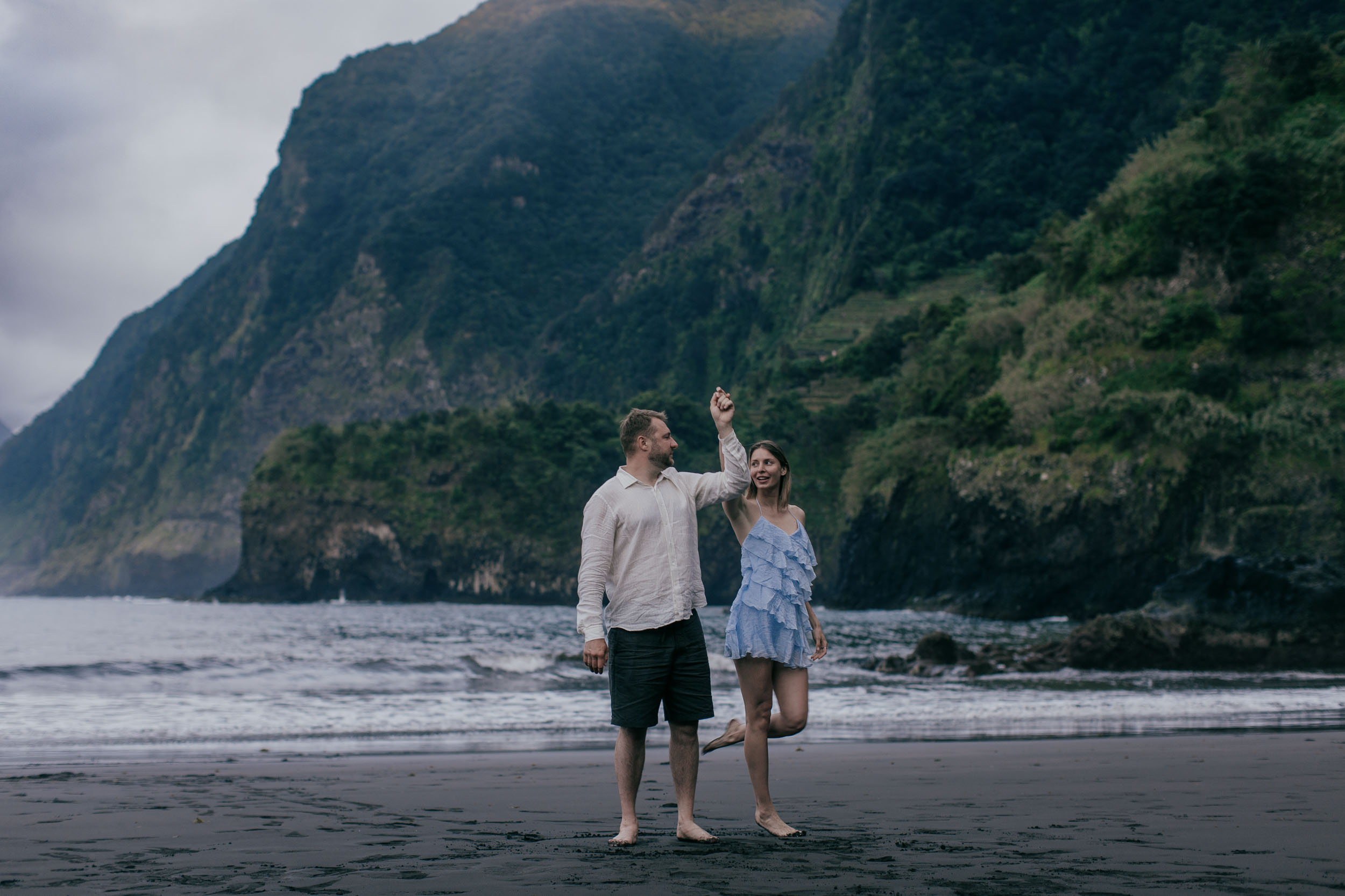 Close intimate moment at golden hour, the couple in soft warm light, Atlantic behind, Madeira