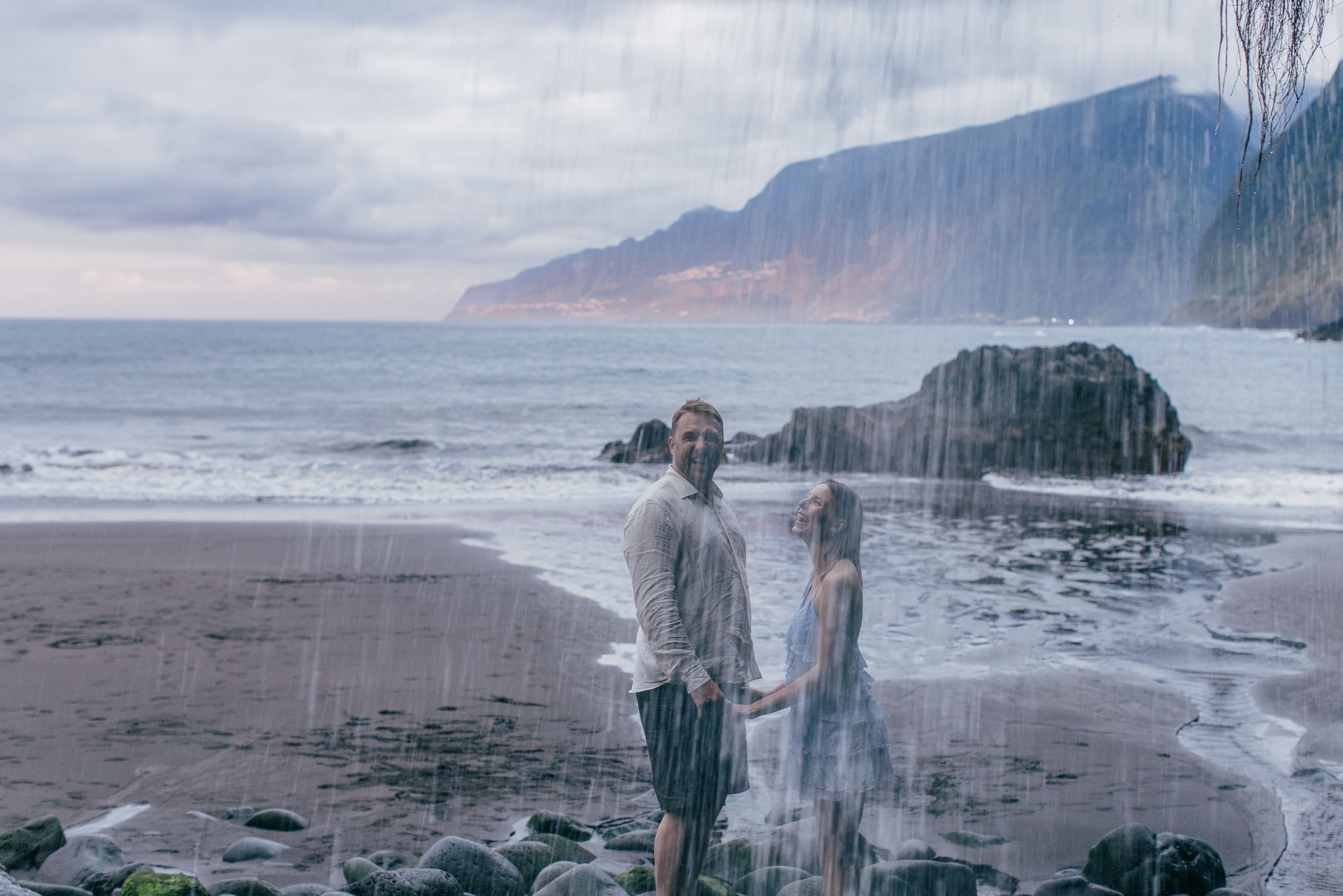 She on a black volcanic rock formation, the Atlantic stretching behind, Madeira