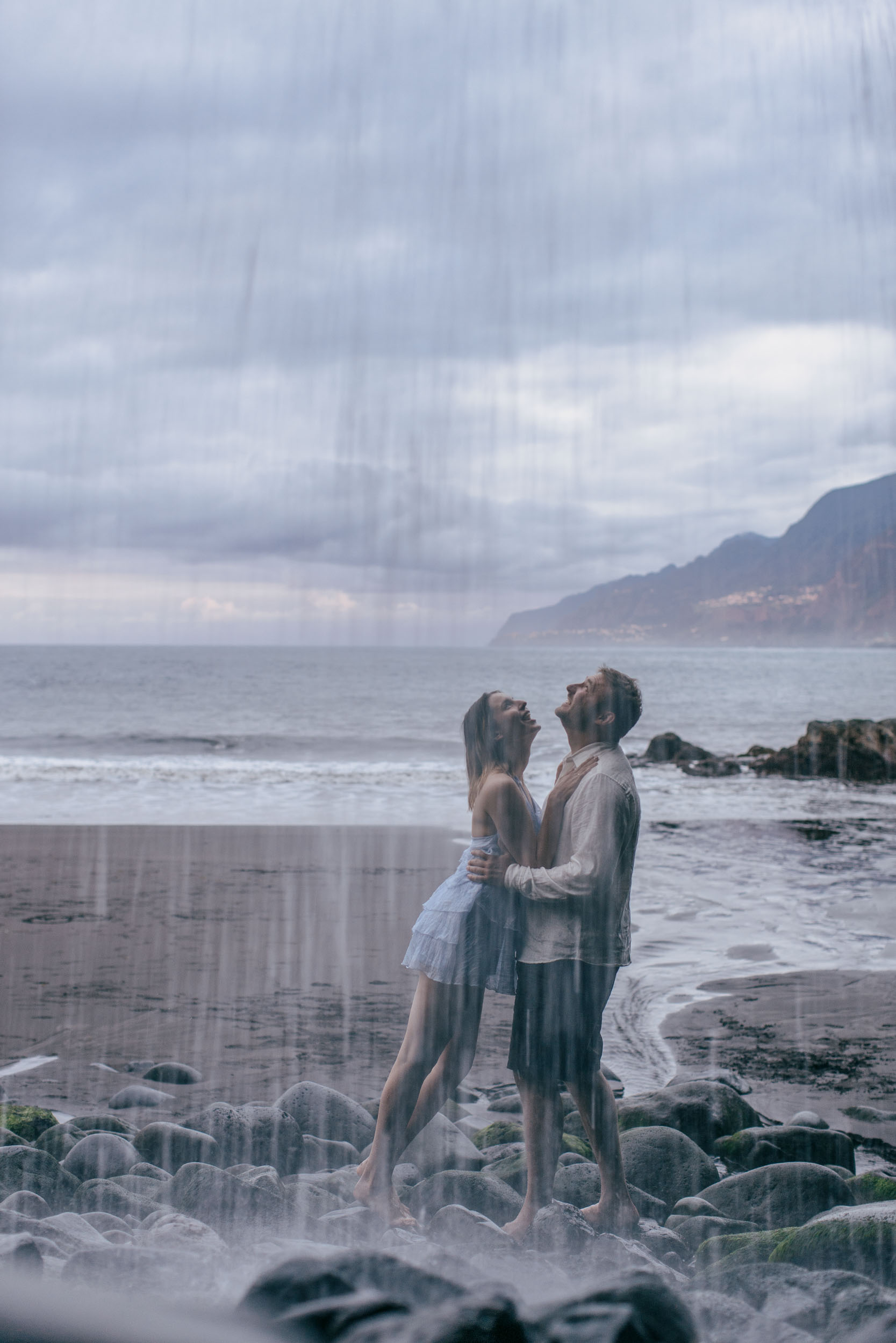 Pale blue dress against black volcanic stacks, the Atlantic behind, Madeira