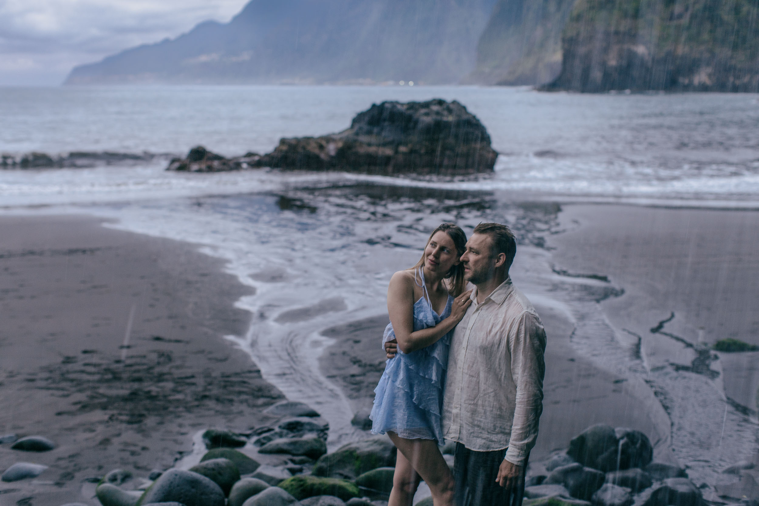 She on a black volcanic rock formation, the Atlantic stretching behind, Madeira