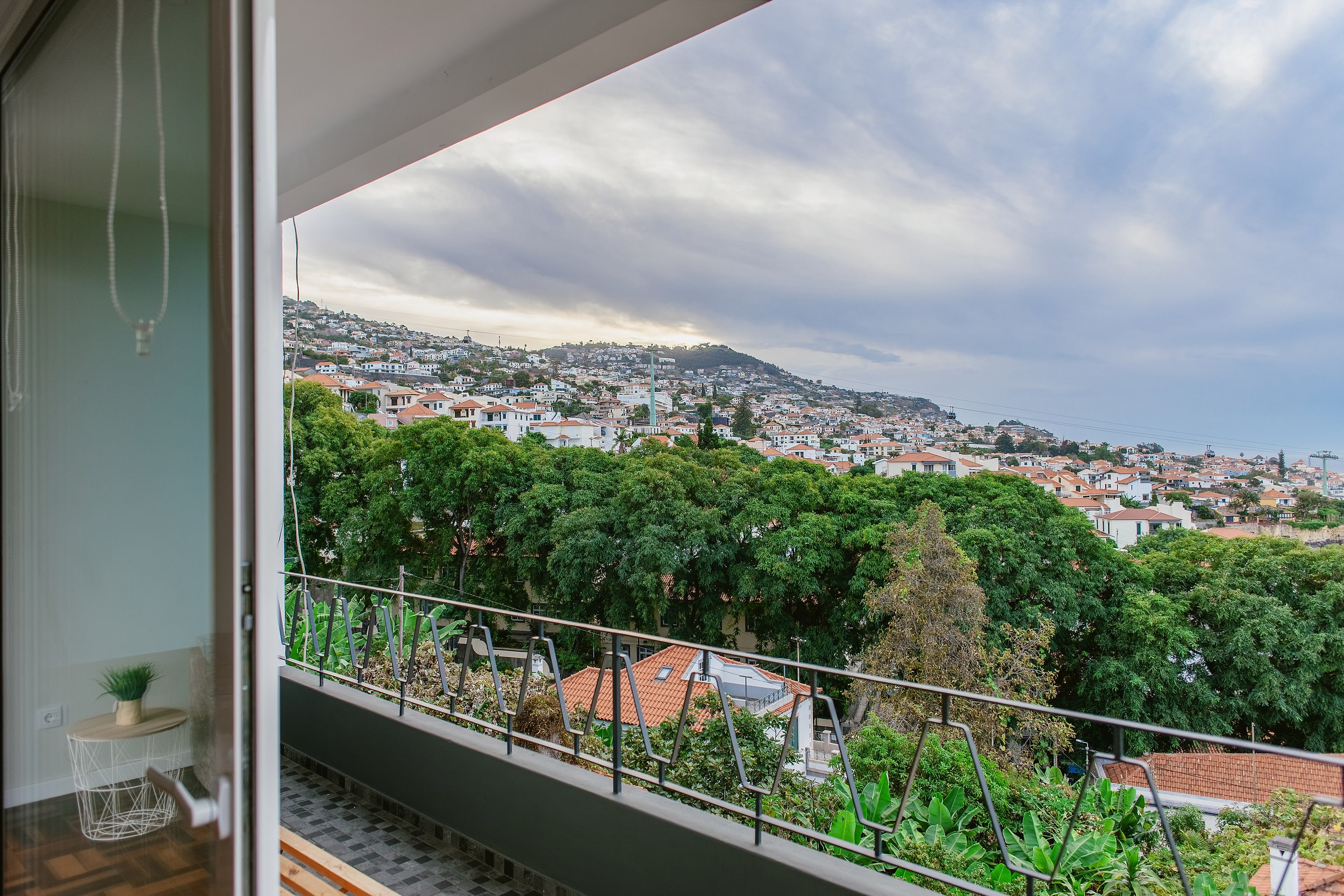 View from the balcony over the green hillside of Funchal under grey cloud