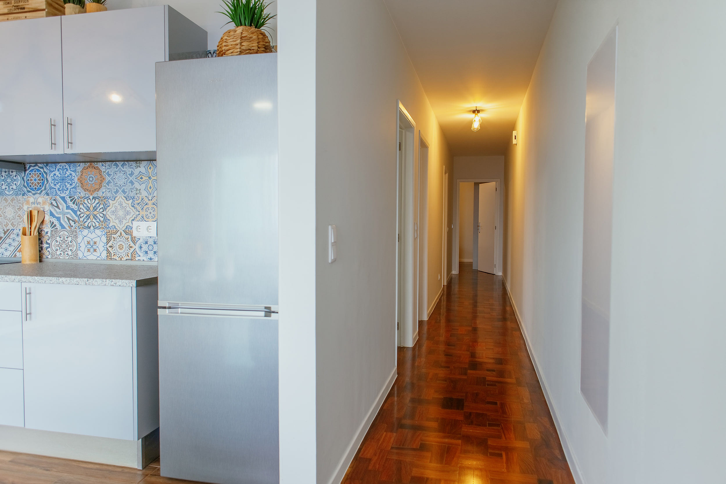Corridor with a parquet floor leading from the kitchen to the bedrooms