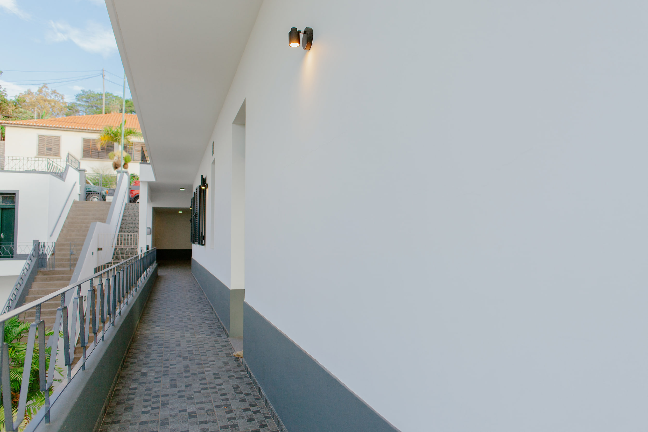 Access path along the building with a wall lamp and steps up to the street