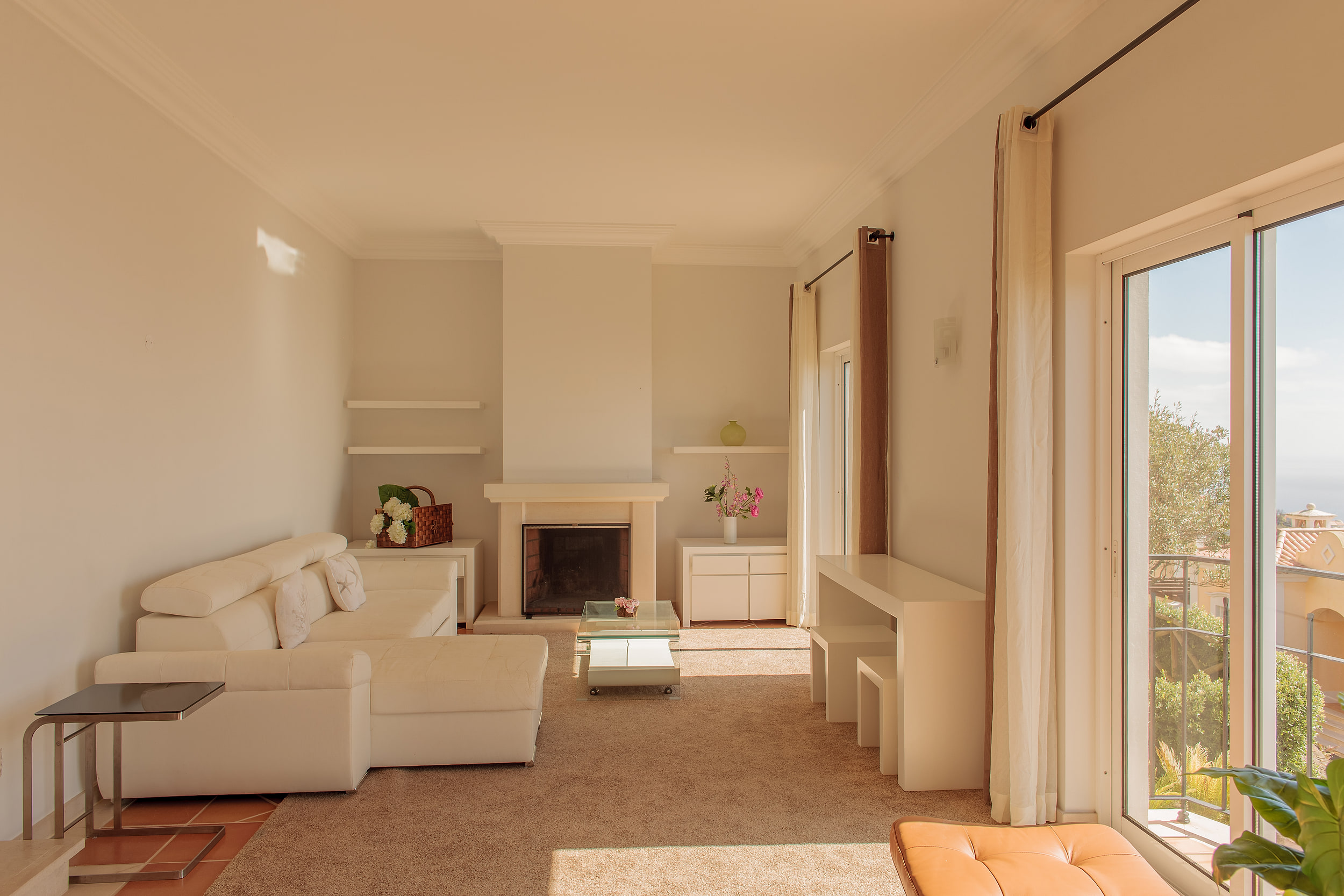 Living room from the other end, the fireplace between shelves, long curtains and balcony doors on the right
